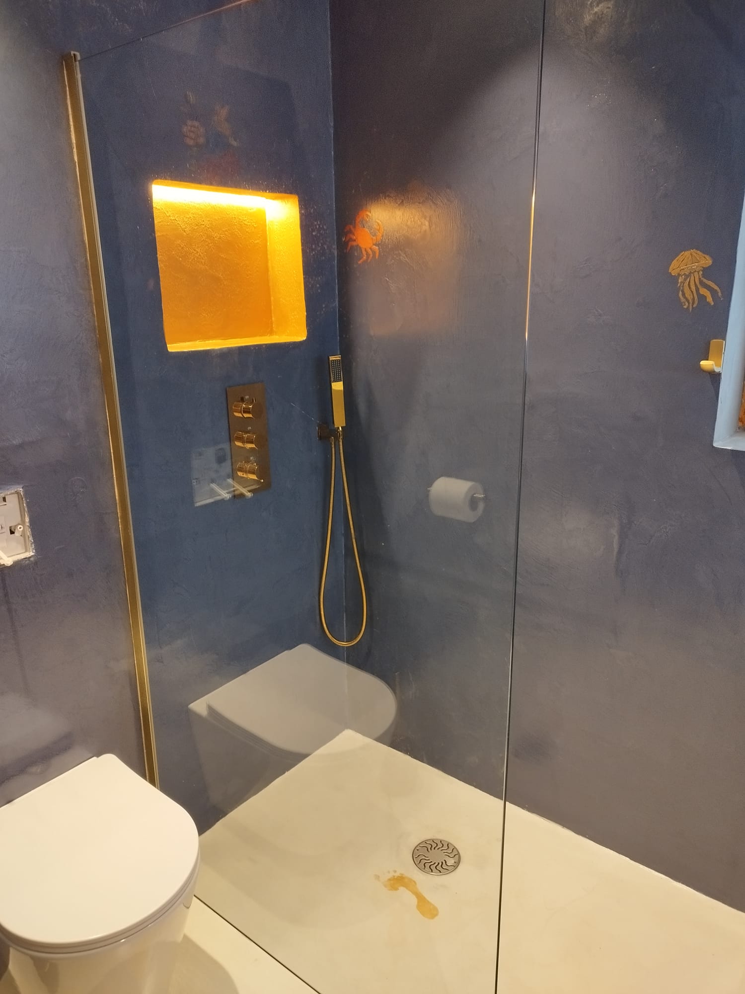 Microcement wet room with rich blue surfaces and elegant fittings